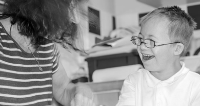Child laughing with teacher in classroom