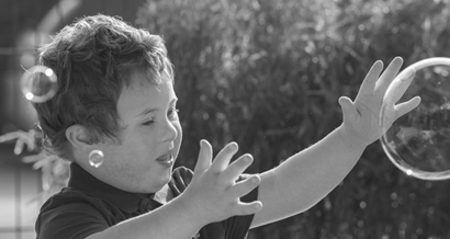 Child playing outside with bubbles